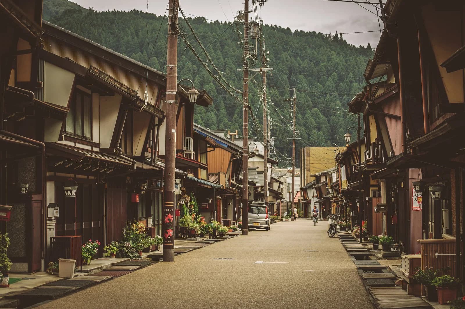 山を背にした昭和の街並みの通り。戸建てが並ぶ住宅地の風景