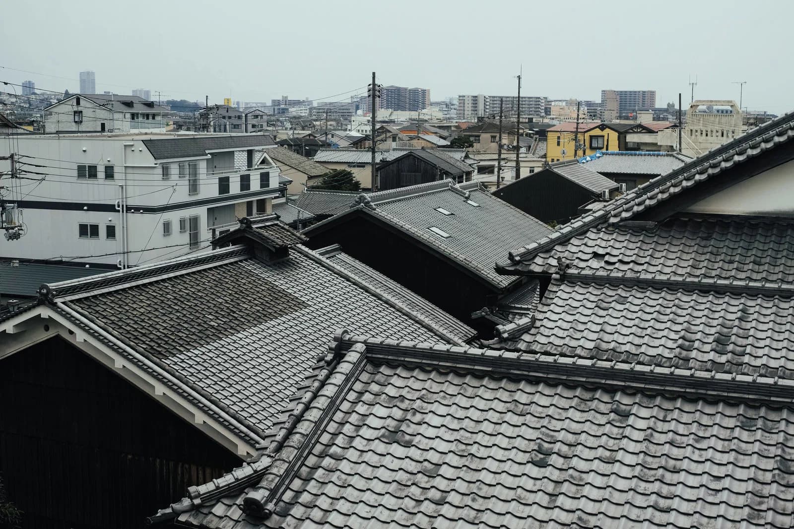 瓦屋根の住宅を見下ろす風景。共有名義の不動産のイメージ